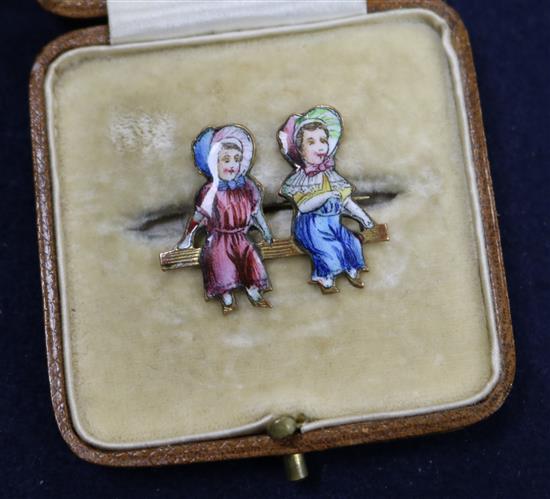 A Kate Greenaway style brooch enamelled with two children, 29mm.